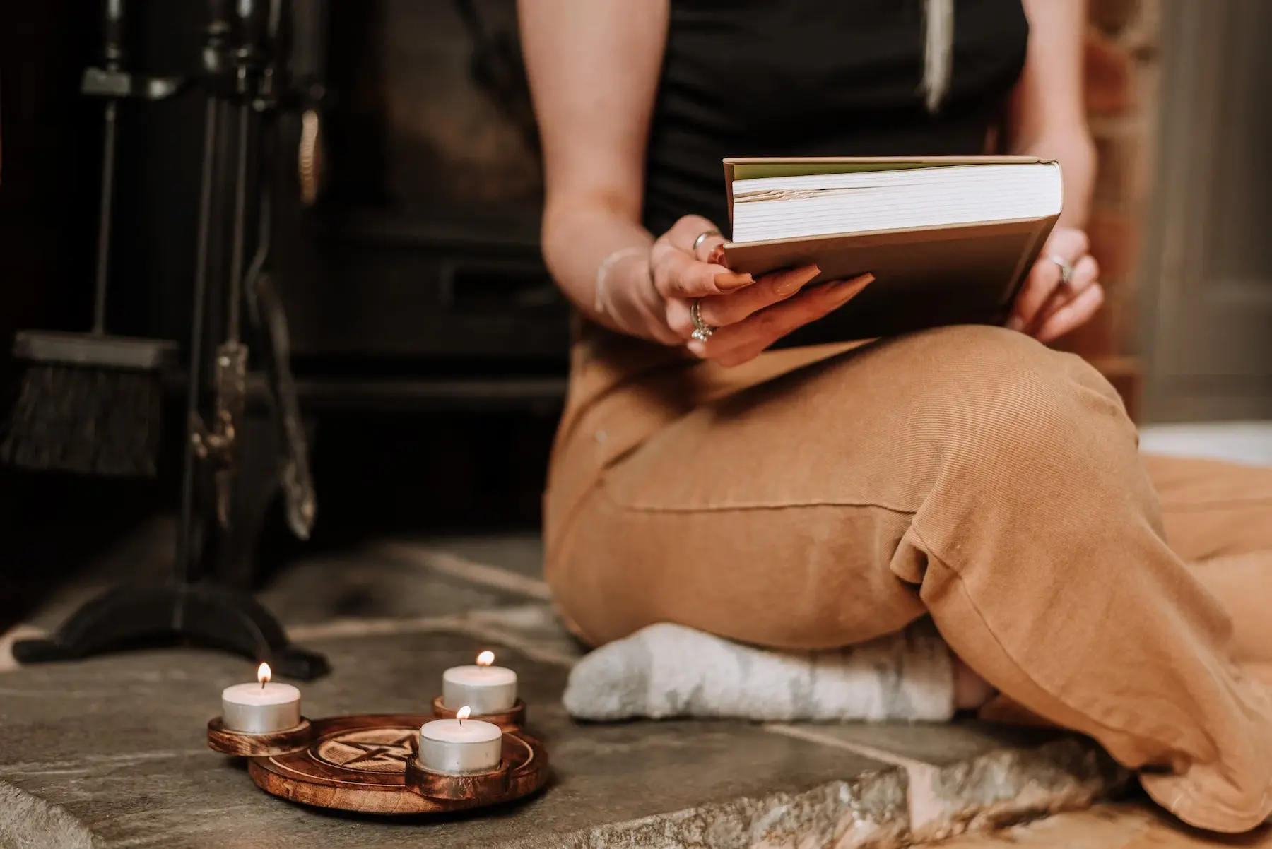una persona sentada en el piso con un libro