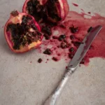 Un cuchillo cortando una fruta de granada