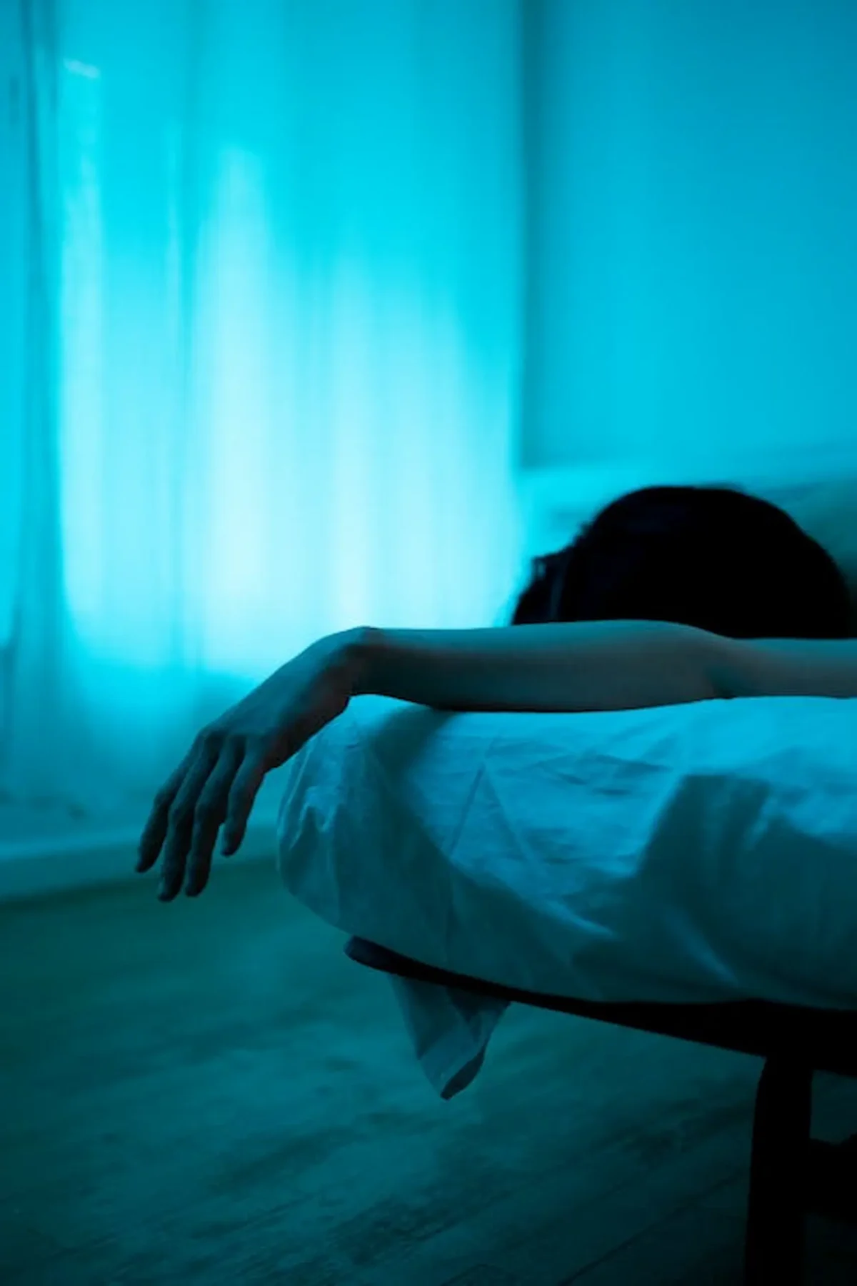una mujer acostada boca abajo al borde de la cama
