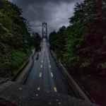 Una carretera hacia un puente mientras el cielo está nublado