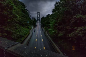 Una carretera hacia un puente mientras el cielo está nublado