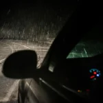 un carro guiando de noche y bajo lluvia