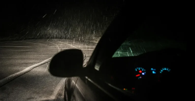 un carro guiando de noche y bajo lluvia